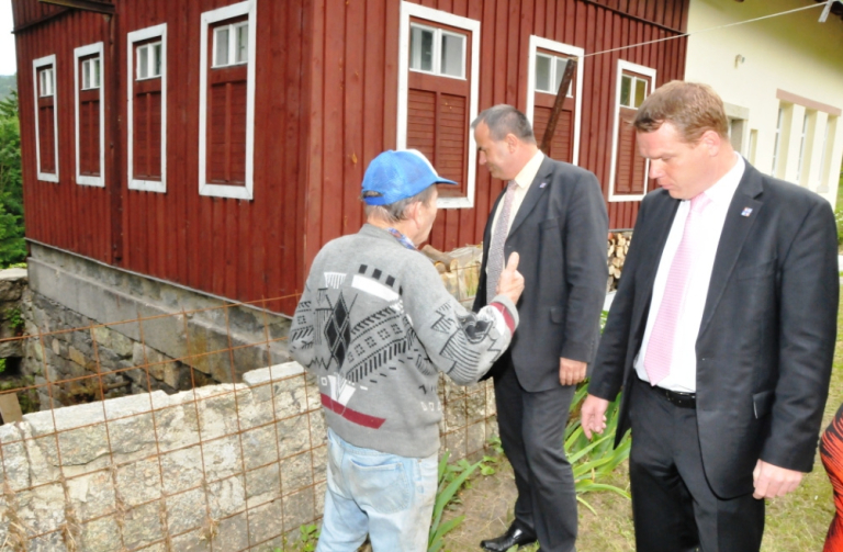 Hejtman (uprostřed) a Pavel Petráček (vpravo) diskutují s místním občanem, kterému voda odnesla podpěrné zdi u domu